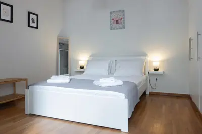 a white bed in a room with two towels on it at Spacious Central Flat in the heart of Athens! in Athens