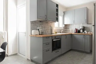 a kitchen with white cabinets and a counter top at Spacious Central Flat in the heart of Athens! in Athens