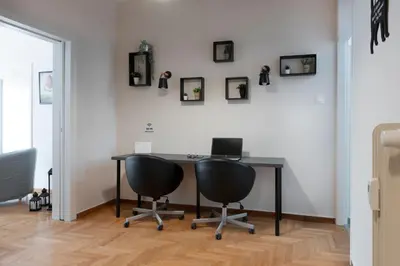 an office with a desk with a laptop and two chairs at Spacious Central Flat in the heart of Athens! in Athens