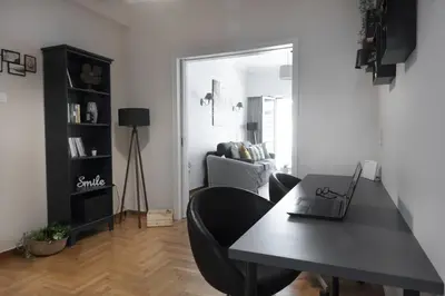 a living room with a table with a laptop on it at Spacious Central Flat in the heart of Athens! in Athens