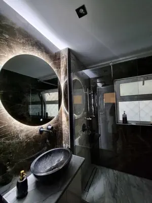 a bathroom with a sink and a round mirror at Arman Group Lannister in Athens