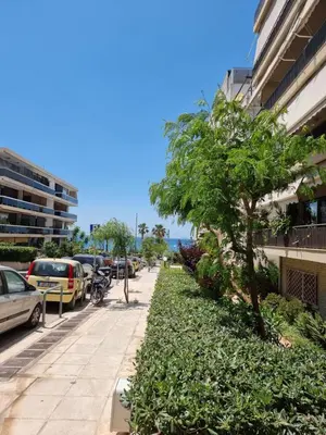 a sidewalk with a tree next to a building at Arman Group Lannister in Athens