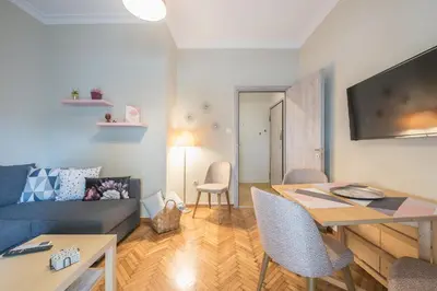 a living room with a couch and a table at Supreme Suite with balcony by Cloudkeys in Athens