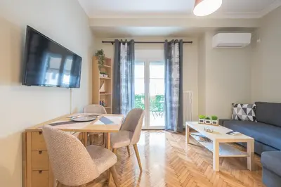 a living room with a table and a blue couch at Supreme Suite with balcony by Cloudkeys in Athens