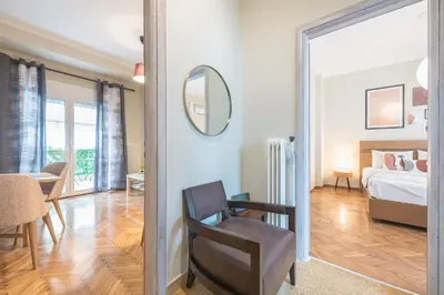a room with a bed and a chair and a mirror at Supreme Suite with balcony by Cloudkeys in Athens