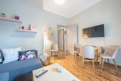 a living room with a couch and a table and chairs at Supreme Suite with balcony by Cloudkeys in Athens