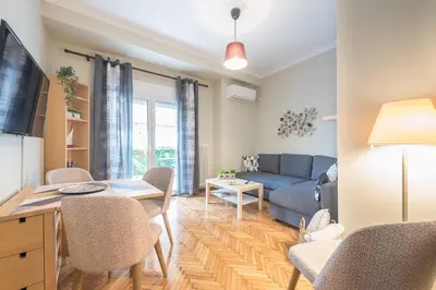 a living room with a couch and a table at Supreme Suite with balcony by Cloudkeys in Athens
