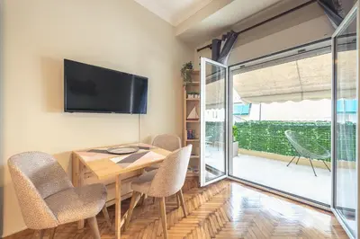 a dining room with a table and chairs and a television at Supreme Suite with balcony by Cloudkeys in Athens