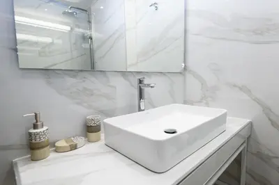 a white bathroom with a sink and a mirror at Crossroads Athens by YHA in Athens