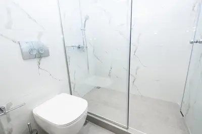 a white bathroom with a toilet and a shower at Crossroads Athens by YHA in Athens