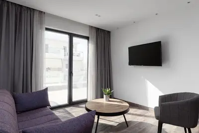 a living room with a couch and a tv at Athenian Spirit in Athens