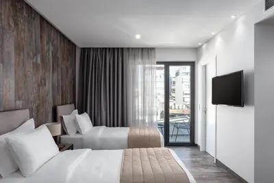 a hotel room with two beds and a flat screen tv at Athenian Spirit in Athens