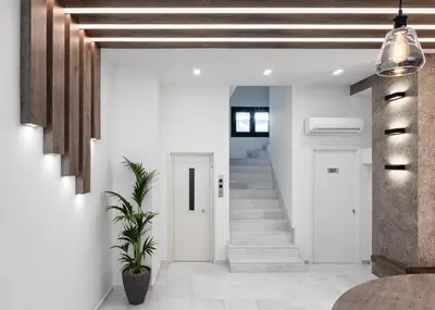 a hallway with white walls and a staircase with white floors at Athenian Spirit in Athens