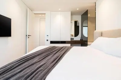 a bedroom with a large white bed and a mirror at 5BD Luxury Penthouse with Sea View in Athens