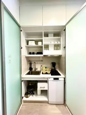 a small kitchen with white cabinets and a sink at Monastiraki 106 SuperHost Hub in Athens