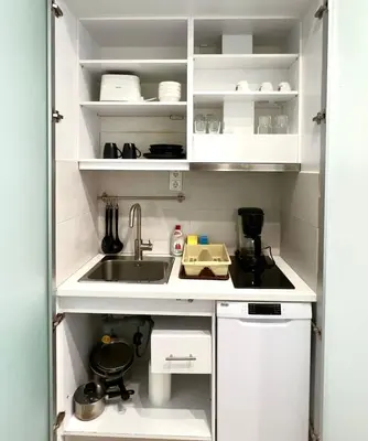 a small kitchen with white cabinets and a sink at Monastiraki 106 SuperHost Hub in Athens