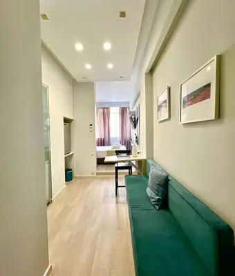 a living room with a green couch and a table at Monastiraki 106 SuperHost Hub in Athens