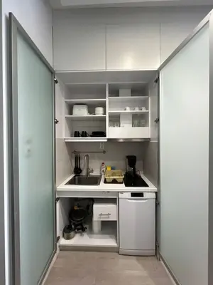 a small kitchen with white cabinets and a sink at Monastiraki 106 SuperHost Hub in Athens