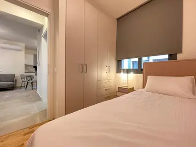 a bedroom with a white bed and a sliding glass door at Athenean Modern Escape near Marina Flisvos in Athens