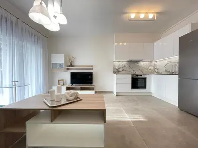 a kitchen with white cabinets and a dining table at Athenean Modern Escape near Marina Flisvos in Athens