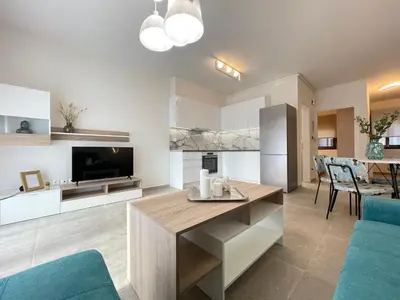 a kitchen and living room with a table and chairs at Athenean Modern Escape near Marina Flisvos in Athens
