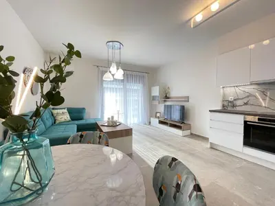 a living room with a blue couch and a table at Athenean Modern Escape near Marina Flisvos in Athens