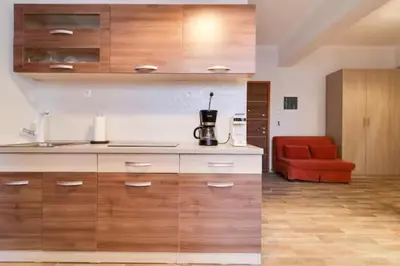 a kitchen with wooden cabinets and a red chair at Monastiraki 212 - 43m2 SuperHost Hub in Athens