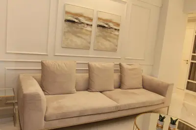 a couch in a living room with two paintings on the wall at Adri & Marg luxury living in Athens