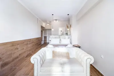 a living room with a white couch and wooden floors at Monastiraki 507 SuperHost Hub in Athens
