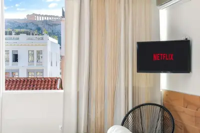 a television in a room with a view of a building at Monastiraki 507 SuperHost Hub in Athens