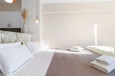 a bedroom with two beds with white sheets and towels at Monastiraki 507 SuperHost Hub in Athens
