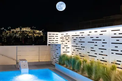a rooftop swimming pool with a moon in the background at Ma Maison No5, Private Heated Pool, Acropolis view in Athens