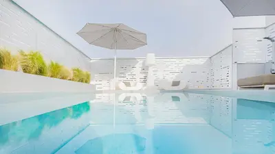 a house with a swimming pool with an umbrella at Ma Maison No5, Private Heated Pool, Acropolis view in Athens