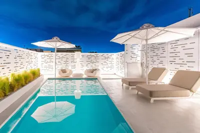 a patio with a pool and chairs and umbrellas at Ma Maison No5, Private Heated Pool, Acropolis view in Athens