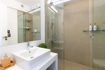 a white bathroom with a sink and a shower at Ma Maison No5, Private Heated Pool, Acropolis view in Athens