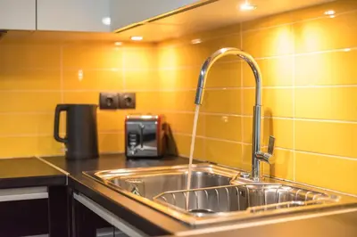 a kitchen sink with a faucet on a counter at Confy Living Apartment Metaxourghio Metro Station in Athens