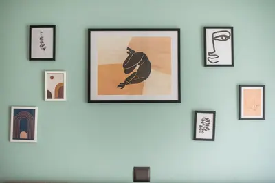 a wall of framed pictures on a wall at Confy Living Apartment Metaxourghio Metro Station in Athens