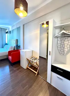 a small apartment with a red couch and a mirror at Monastiraki 508 Central Suite in Athens