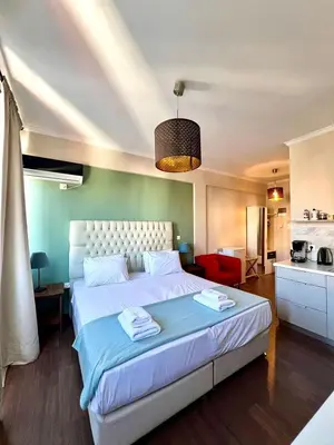 a bedroom with a large bed and a kitchen at Monastiraki 508 Central Suite in Athens