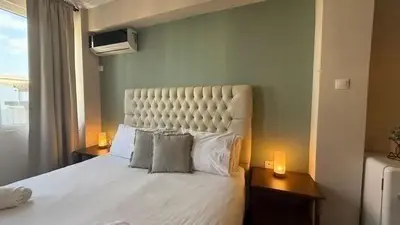 a bedroom with a large white bed with two lamps at Monastiraki 509 Central Suite in Athens