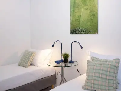 a room with a bed and a table with two lamps at Vouliagmeni‘s Secret Garden near the Sea in Athens