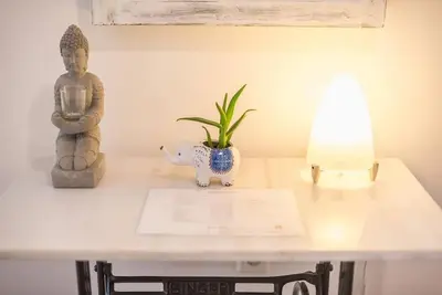 a table with a statue and a plant and a lamp at Casa Pamisou near Attiki metro station in Athens