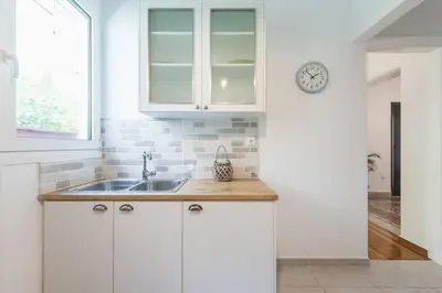 a kitchen with a sink and a clock on a wall at Casa Pamisou near Attiki metro station in Athens