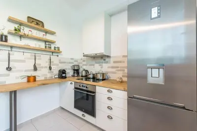 a kitchen with white cabinets and a stainless steel refrigerator at Casa Pamisou near Attiki metro station in Athens