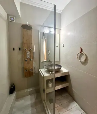 a bathroom with a sink and a glass shower at Monastiraki 312 SuperHost Hub in Athens