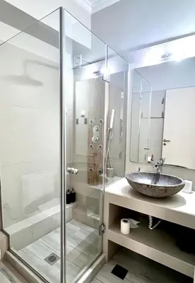 a bathroom with a sink and a glass shower at Monastiraki 312 SuperHost Hub in Athens