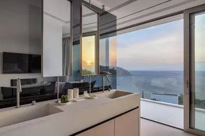 a bathroom with a sink and a large window at Black Stone Villa in Sounio