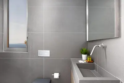 a bathroom with a sink and a mirror and a toilet at Black Stone Villa in Sounio