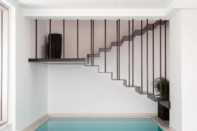 a staircase in a house with a pool at Black Stone Villa in Sounio