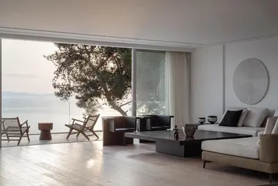 a living room with a couch and a table at Black Stone Villa in Sounio